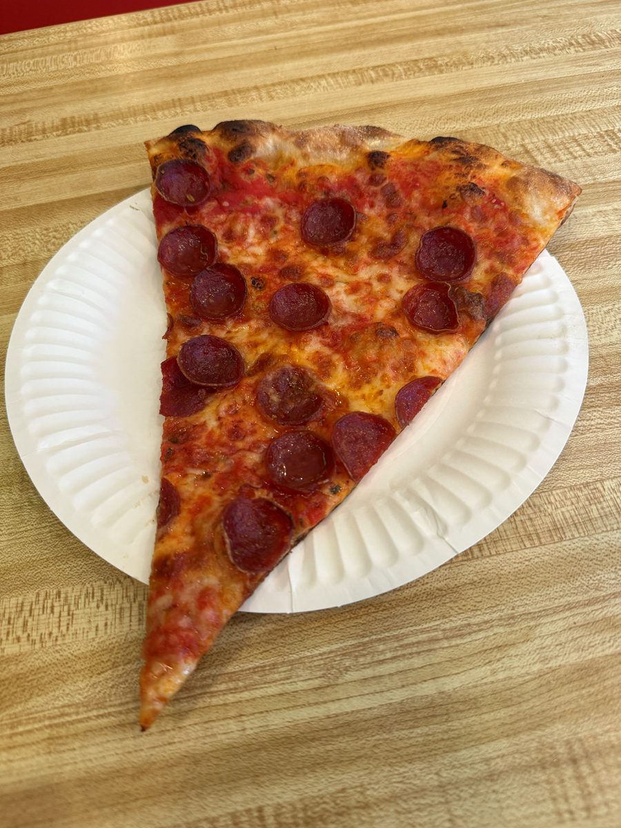pepperoni slice with a blistered, charred edge on a paper plate, Andrea's Pizza
