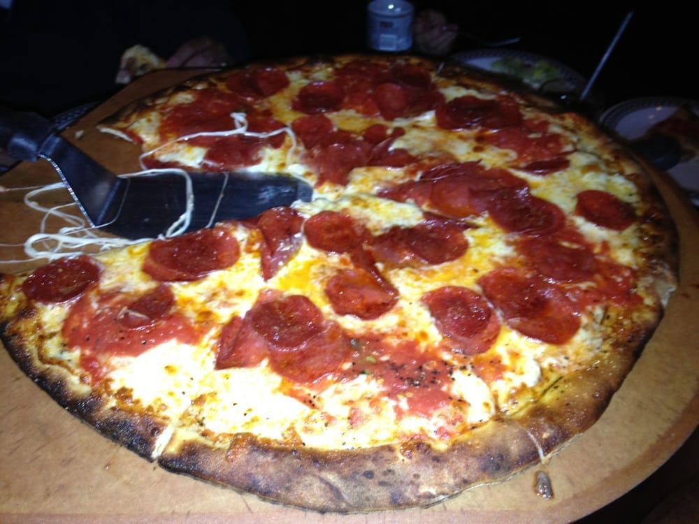 Cheese pulling as pepperoni pie sliced tableside, Anthony's Coal Fired Pizza