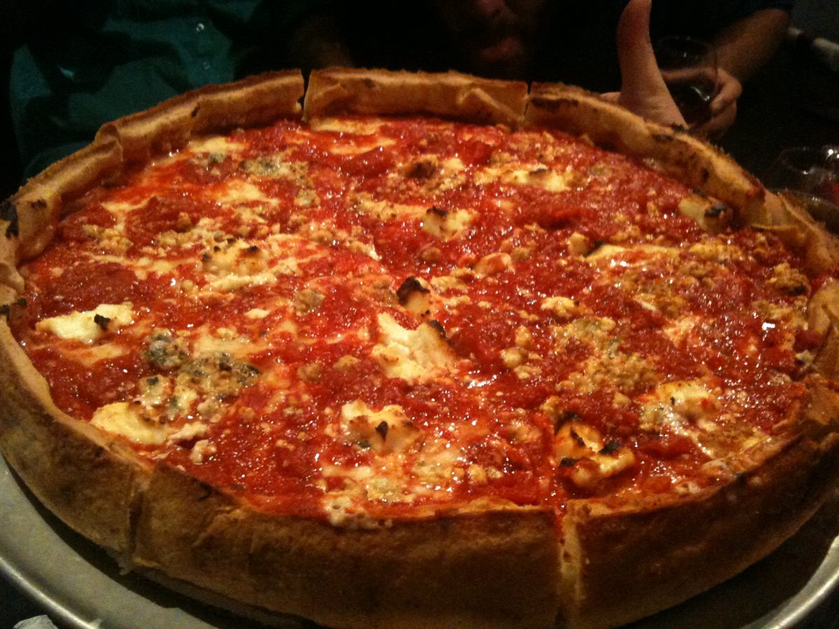 Chunky tomato-topped deep dish with cheese peeking at the edges, Chi-nnati's