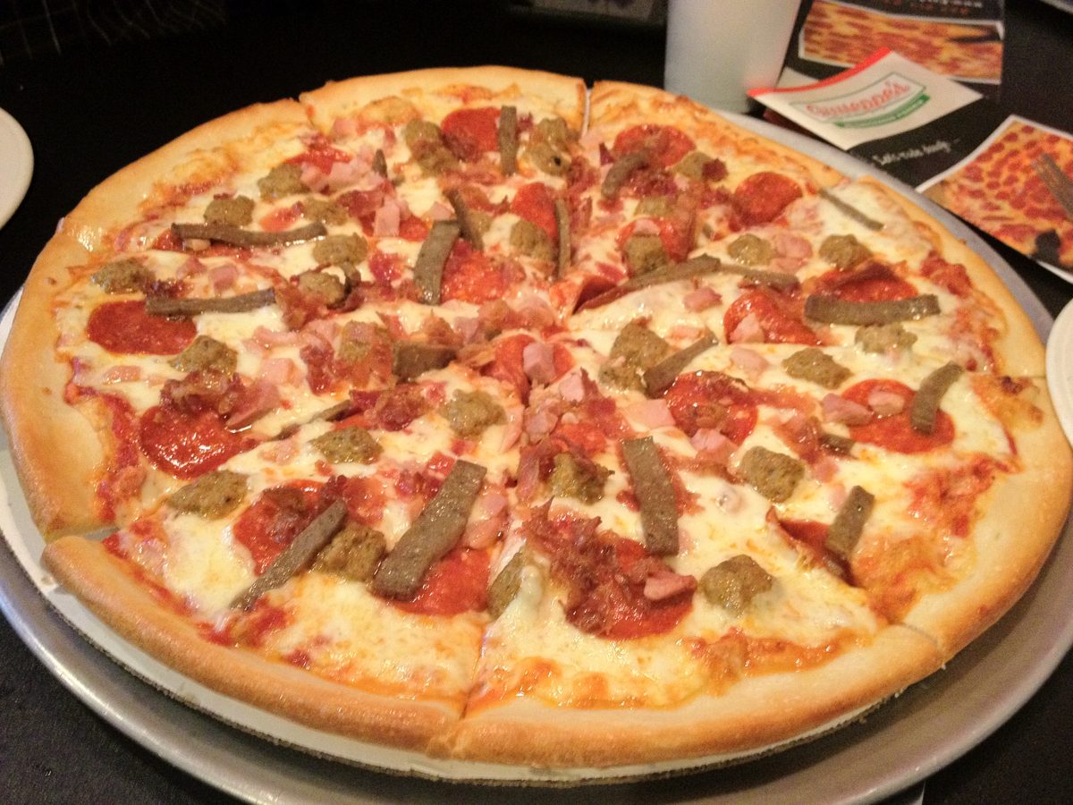 Meat-loaded whole pie with pepperoni, ham cubes, sausage, Giuseppe’s Neighborhood Pizzeria
