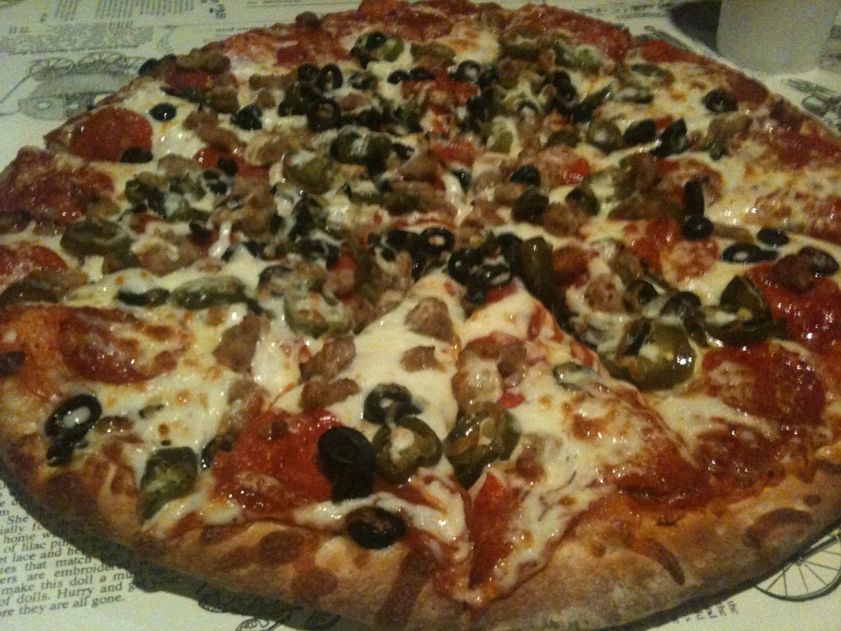 thin pie scattered with black olives and banana peppers, Salvadore’s Pizzeria