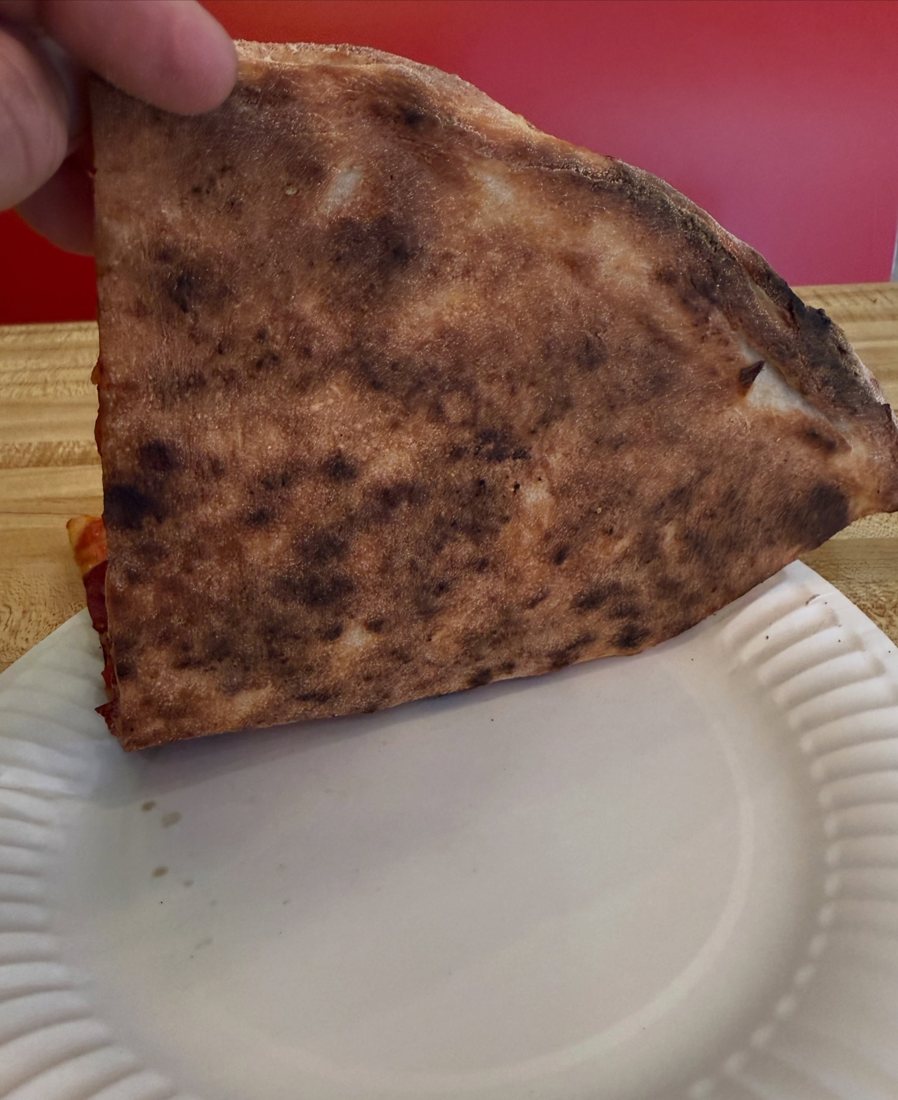 Charred underside of the slice, Andrea’s Pizza