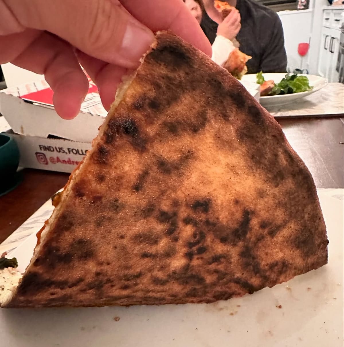 Underside of the pizza crust at Andrew Bellucci’s Pizzeria