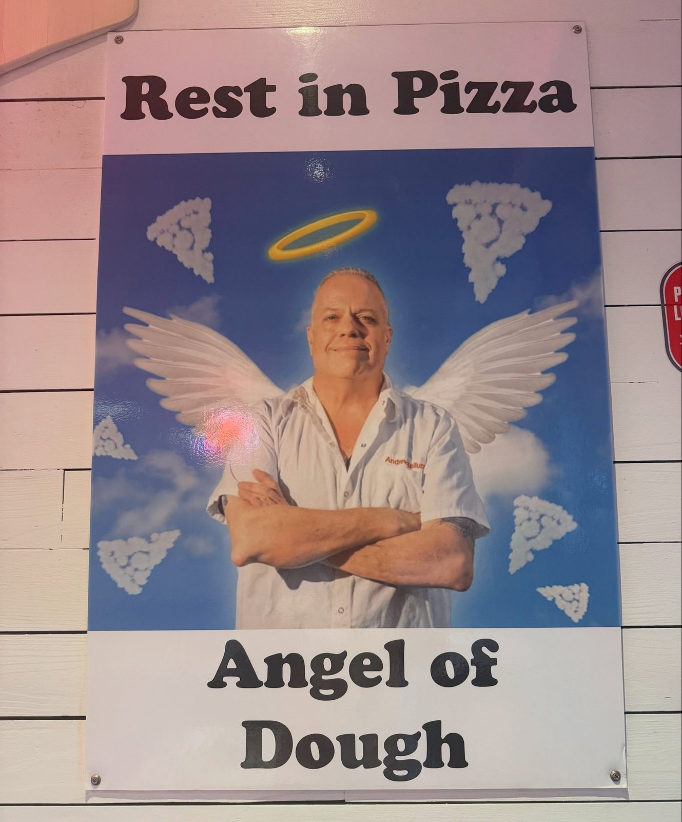 Rest in Pizza tribute poster to Andrew Bellucci on the wall of the pizzeria