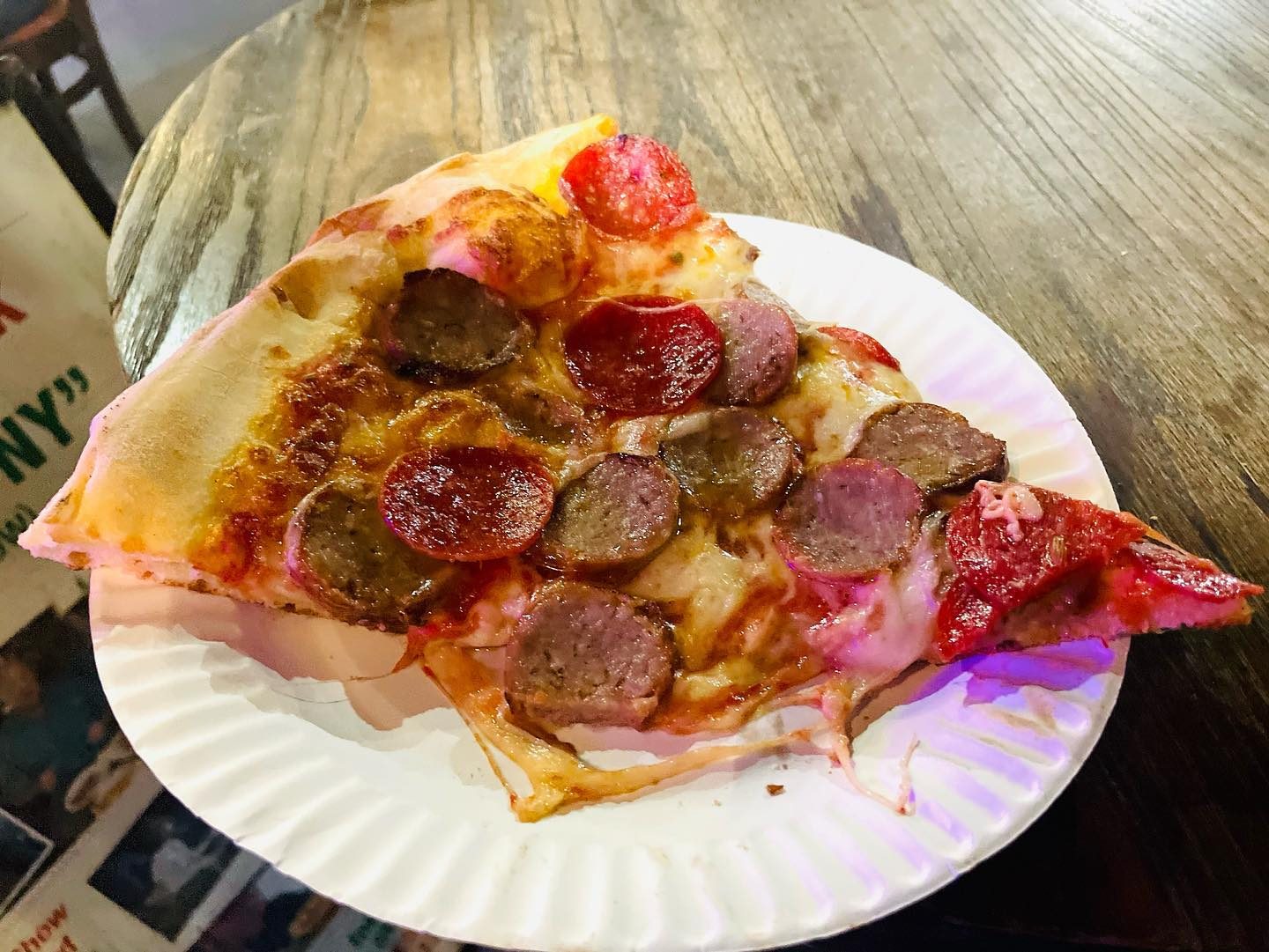 Heavily topped slice on a paper plate at Bleecker Street Pizza