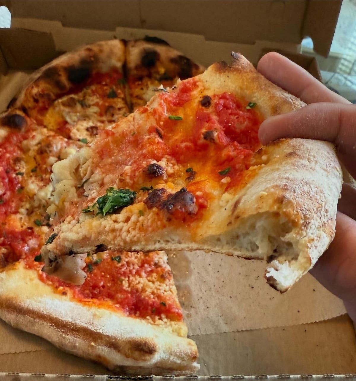 Pizza slice being lifted from the pie at Brewer’s Fork in Charlestown