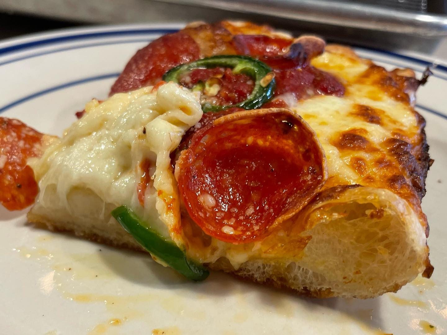 Close view of a pizza slice at Como’s Restaurant