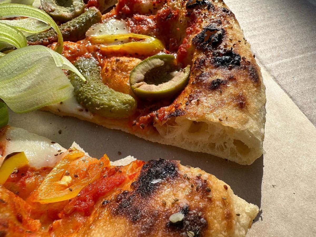 Side profile of a pizza slice at Companion Pizza
