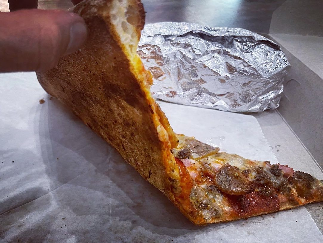 Slice folded to show the crust at Downtown House of Pizza