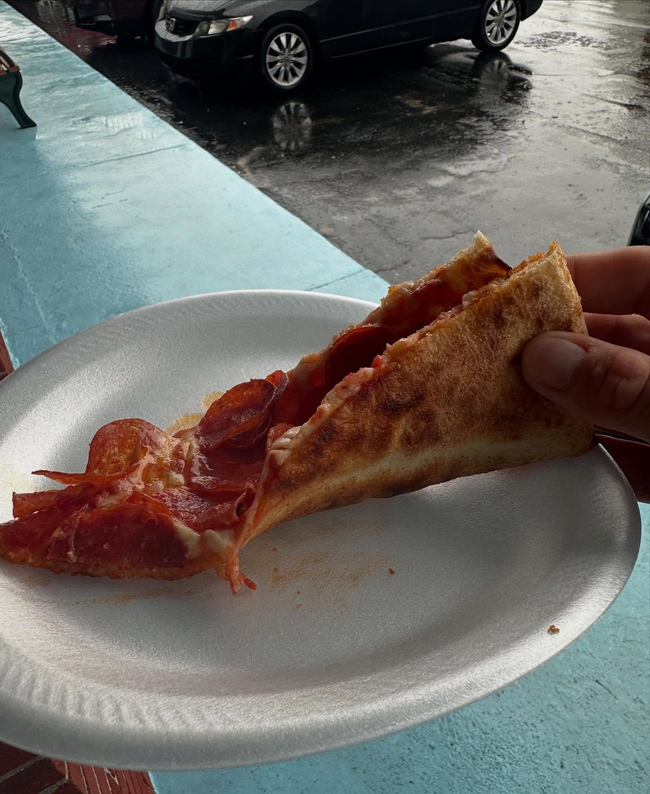 Pizza slice held up for a closer view at Flour Child Pizza