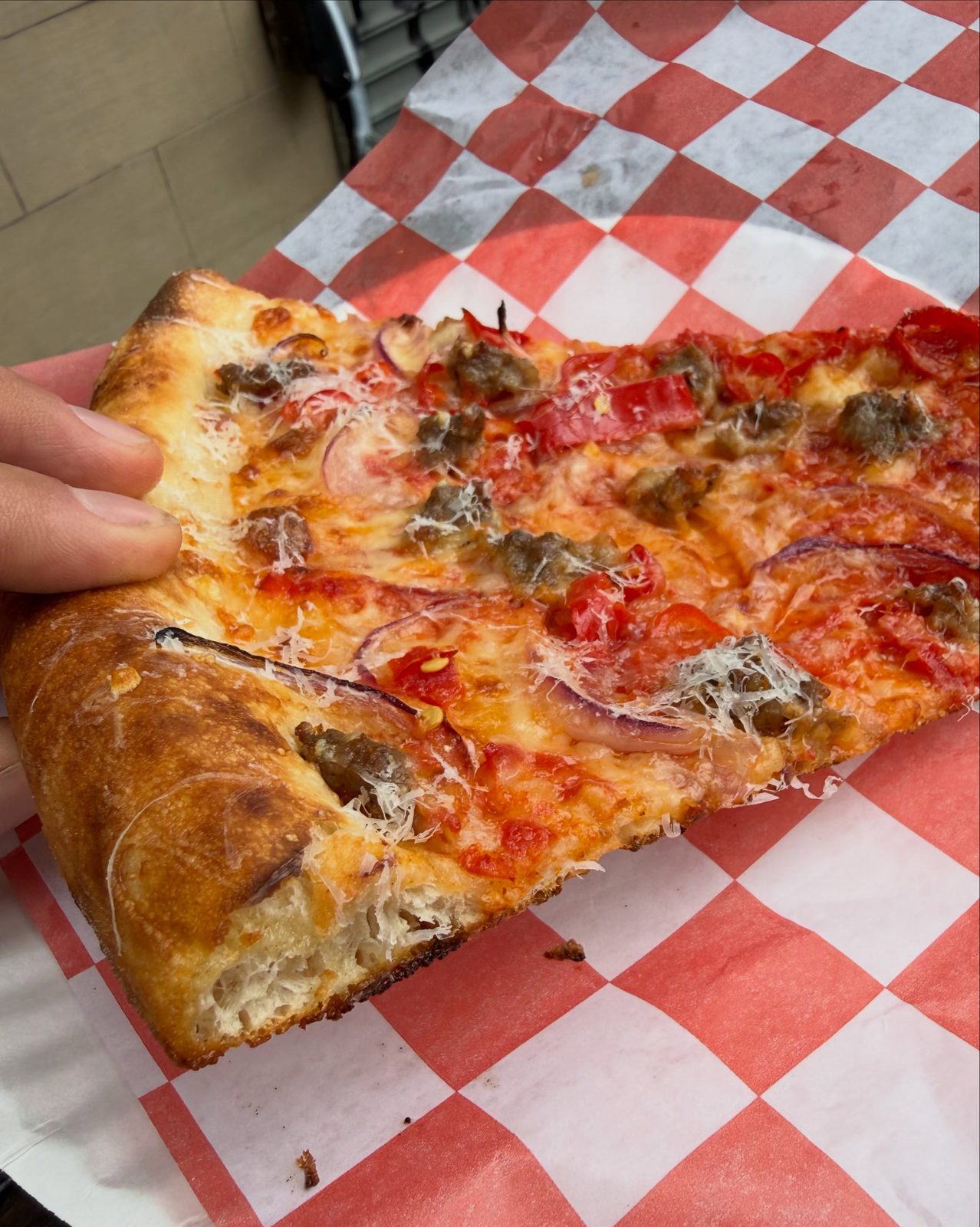 Cornicione of the Hots slice torn open, showing an airy, open crumb