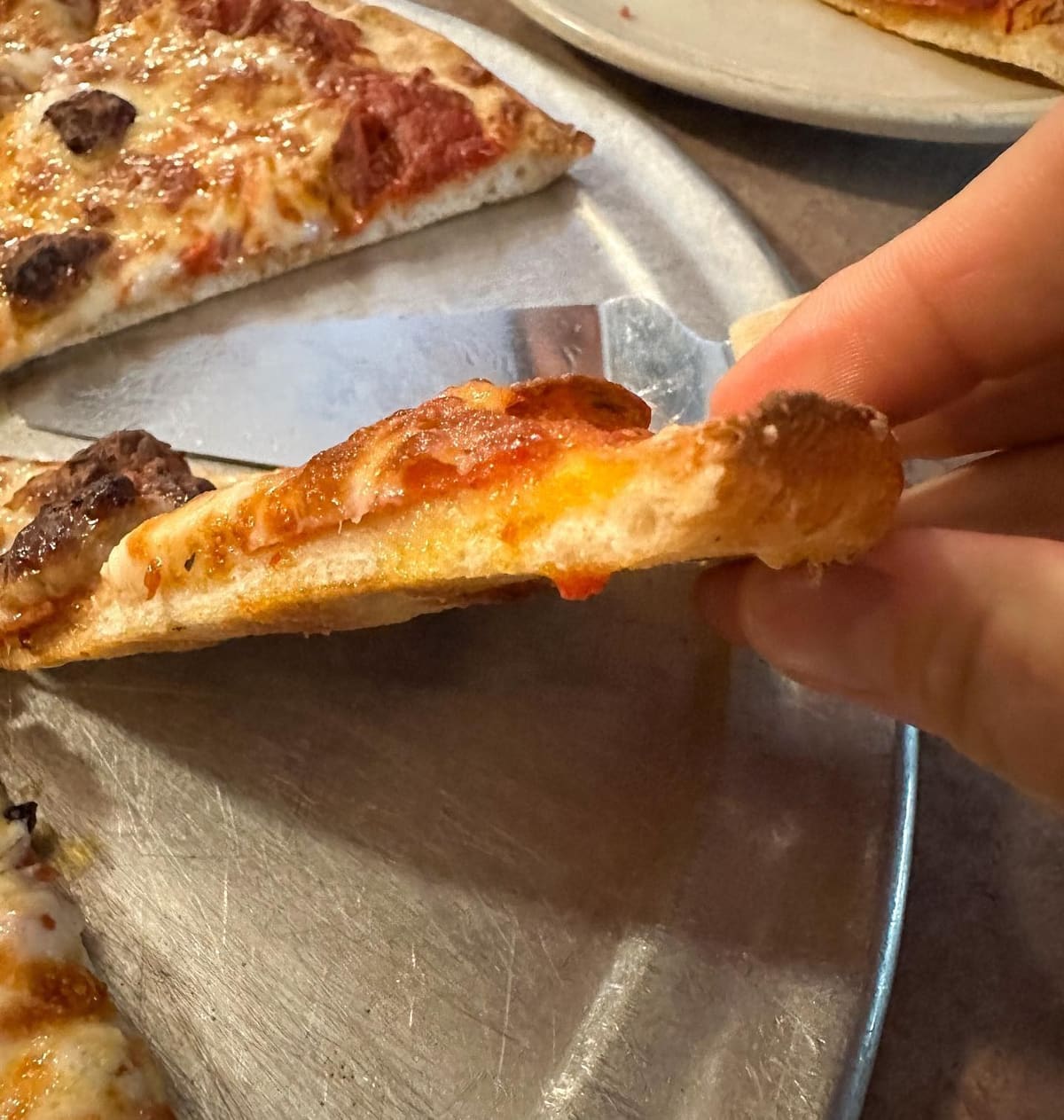Side profile of a pizza slice at Italianette Pizza