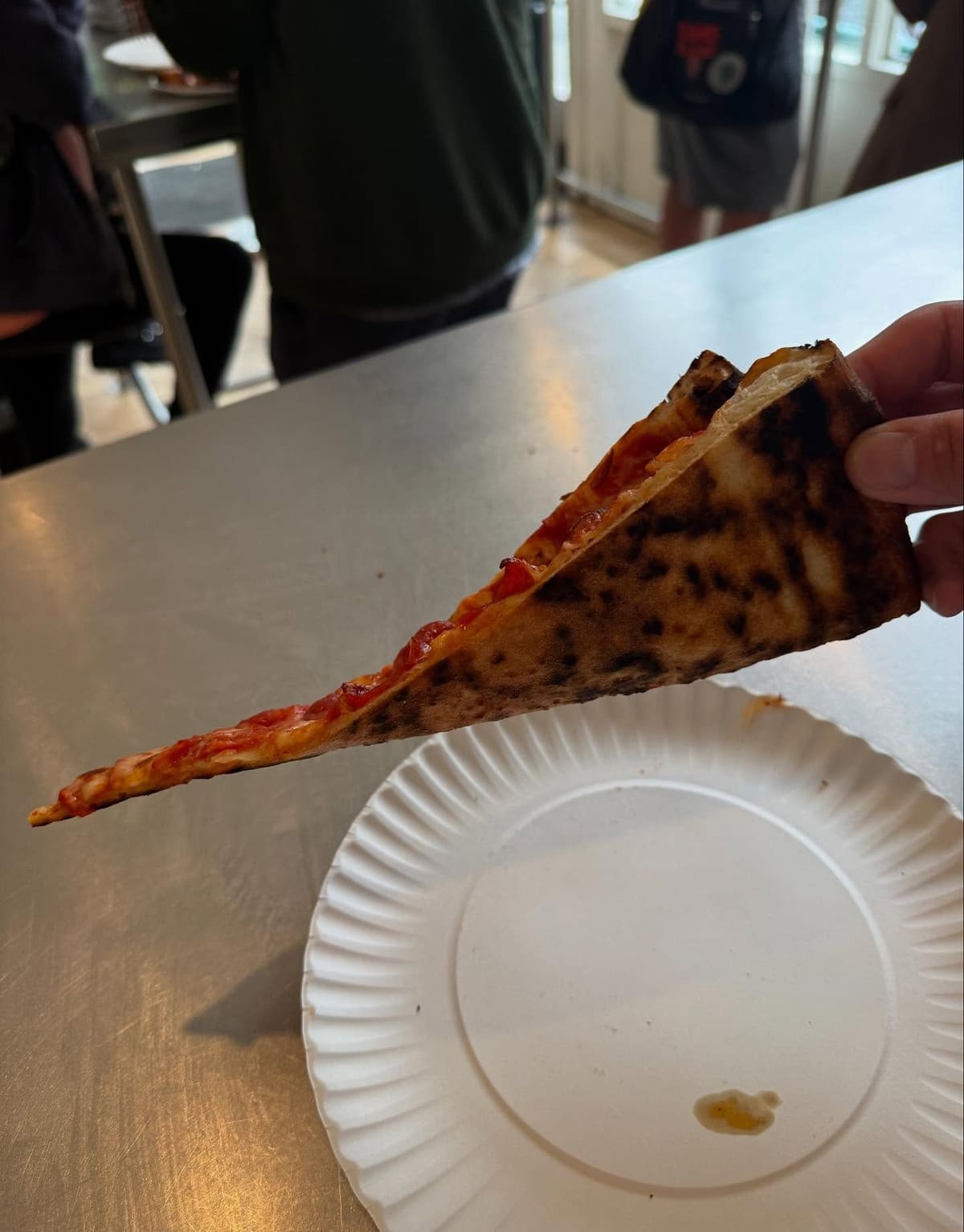 Pizza slice held up for a closer view at Jonny’s Pizza in Lower East Side