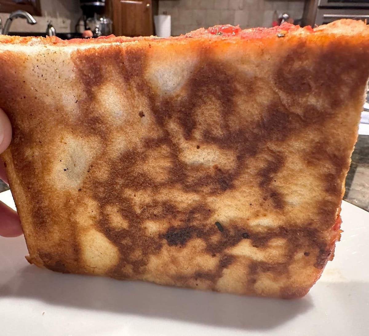 Underside of the pizza crust at L&B Spumoni Gardens