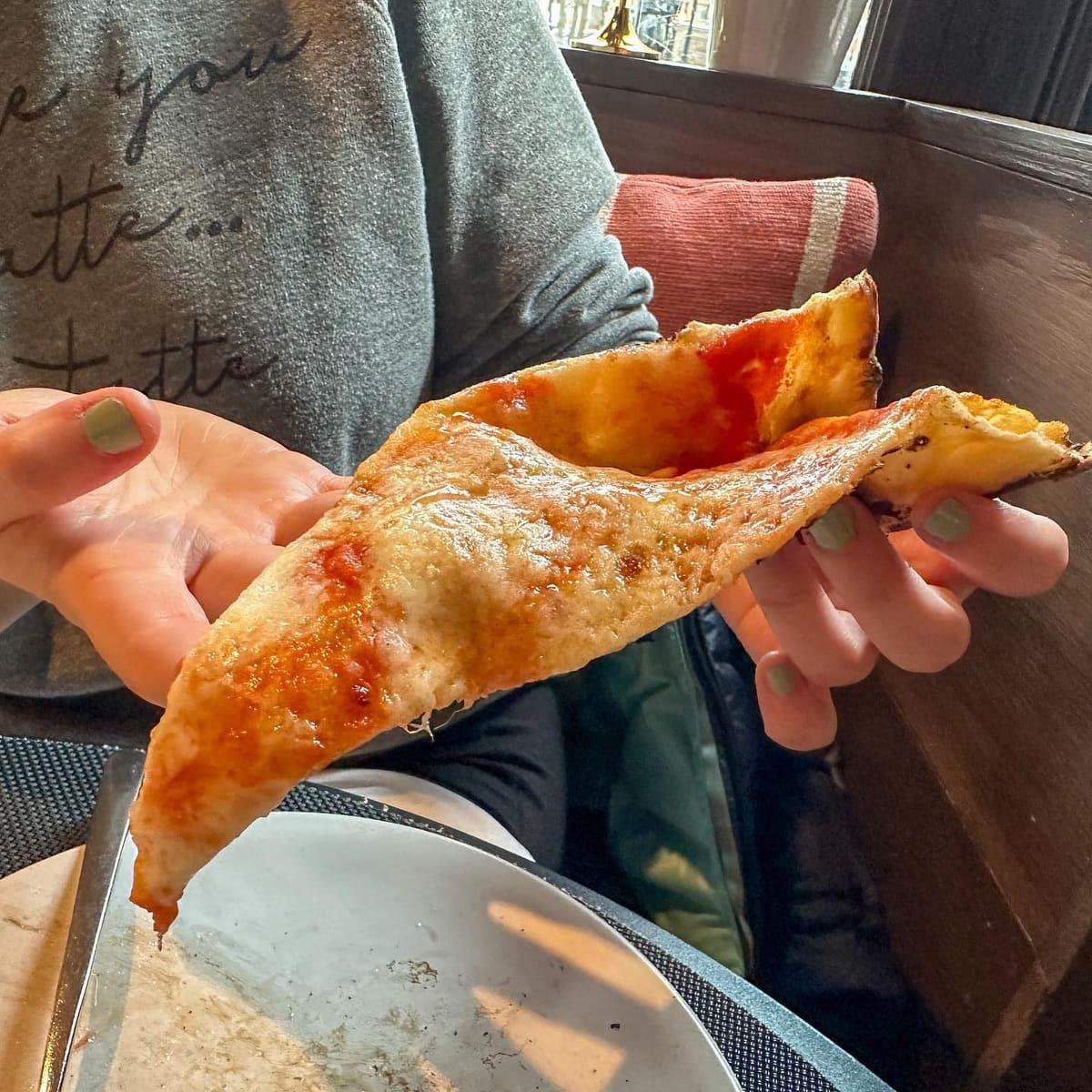 Pizza slice held up for a closer view at L’Antica Pizzeria Da Michele