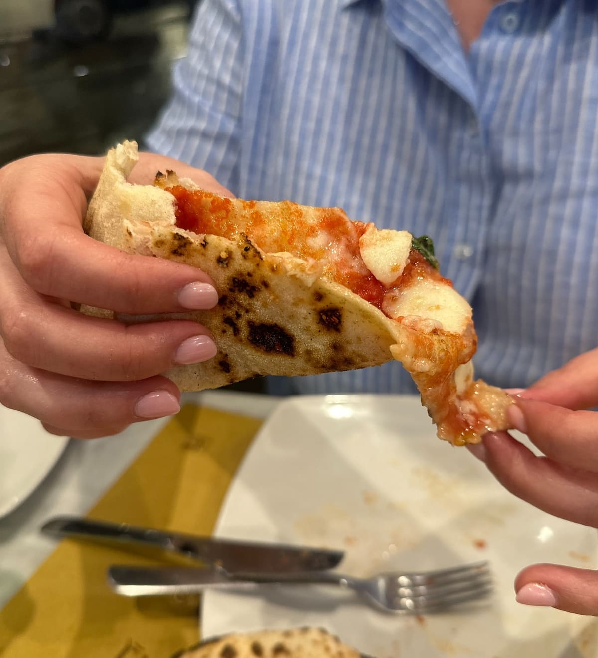 Pizza slice held up for a closer view at L’Antica Pizzeria Da Michele