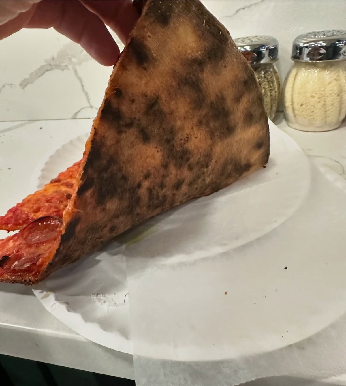 Underside of the pizza crust at Lucia Pizza of Avenue X