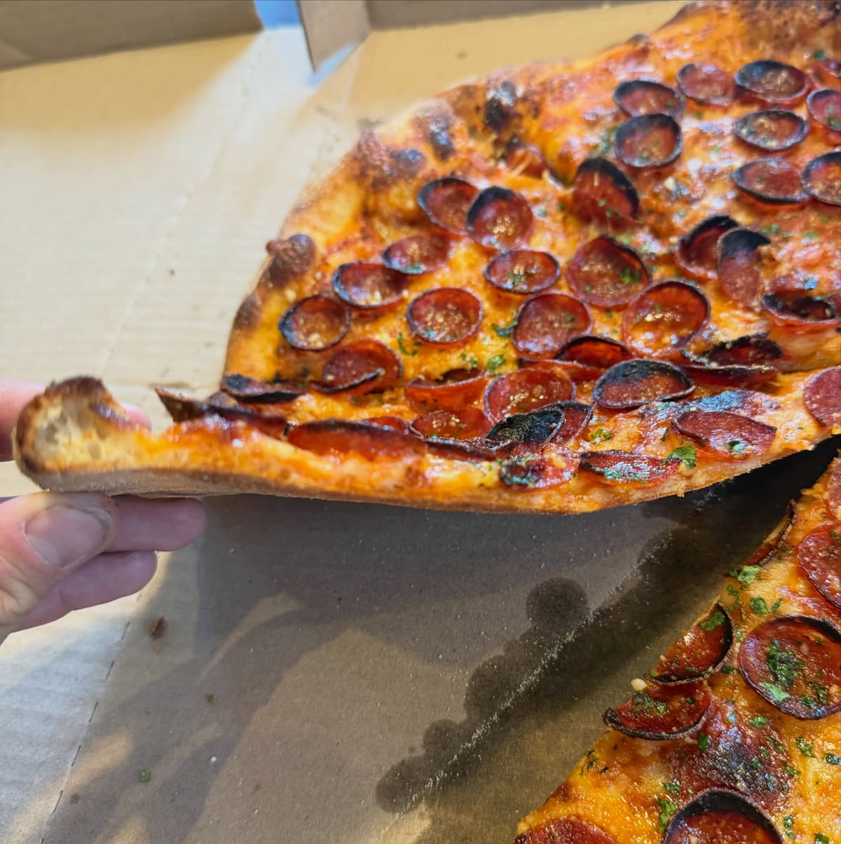 Pizza slice being lifted from the pie at Mad Anthony’s Pizza in Covington, KY