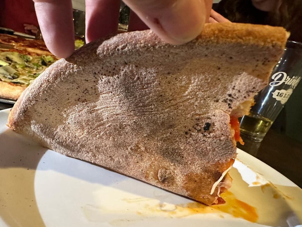 Underside of the pizza crust at Mad Monk’s Pizza