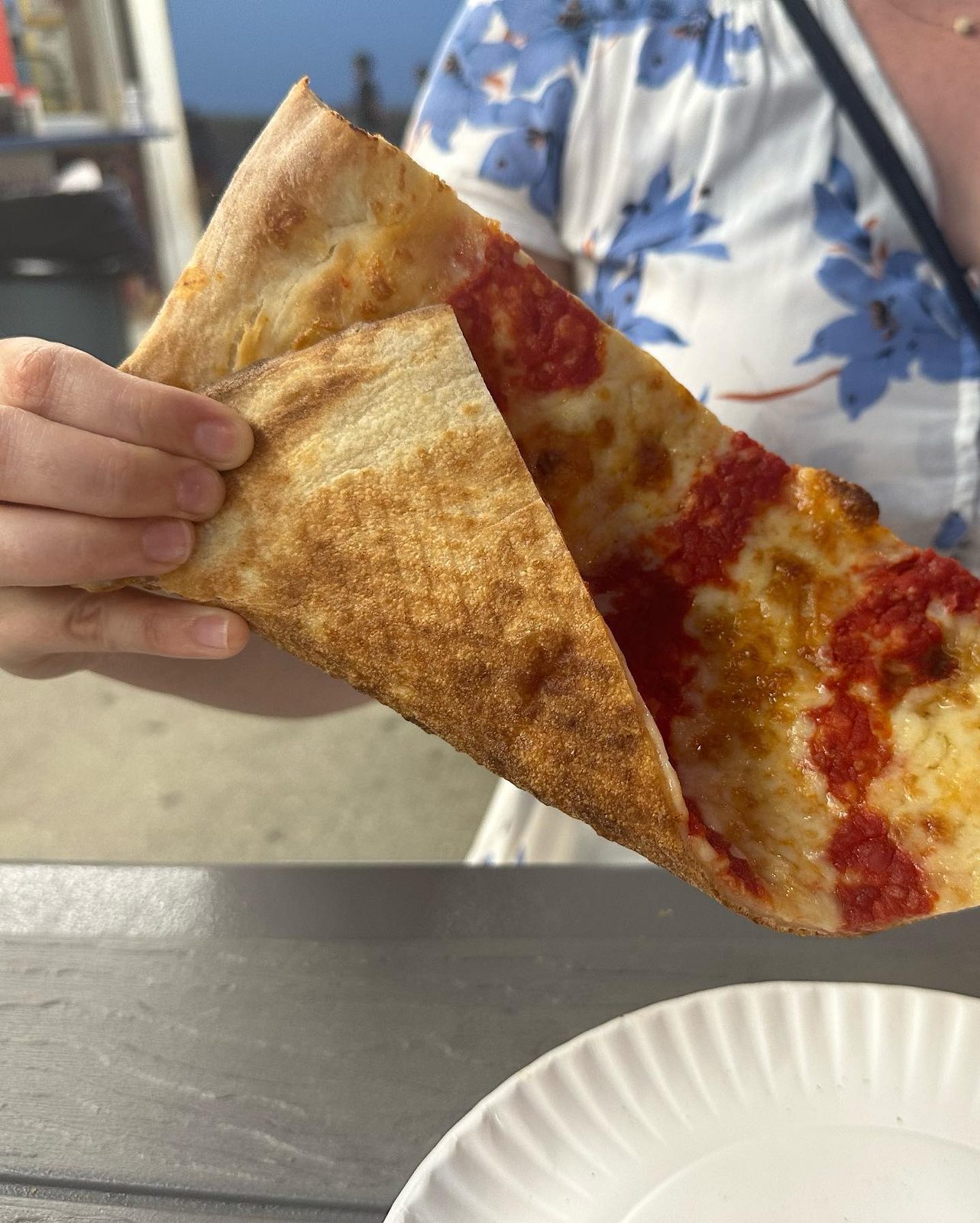Slice folded to show the crust at Maruca’s Tomato Pies