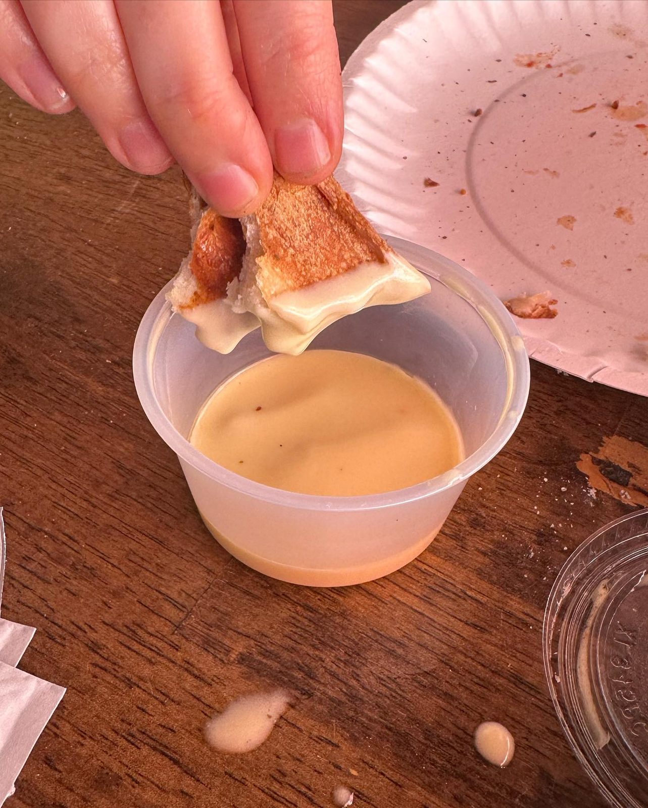 Crust dipped into a cup of Unicorn Sauce at Mikey’s Late Night Slice