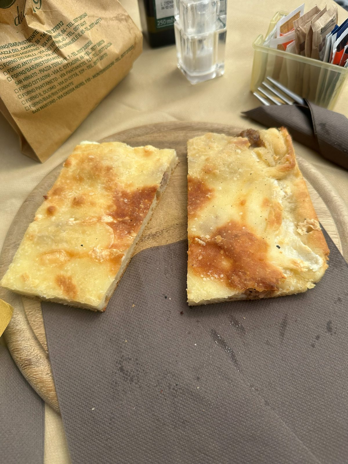 Two pieces of white pizza with no tomato on a board, Panificio Sclavi