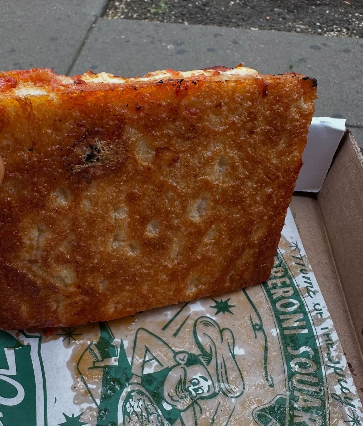 Underside of the pizza crust at Prince Street Pizza