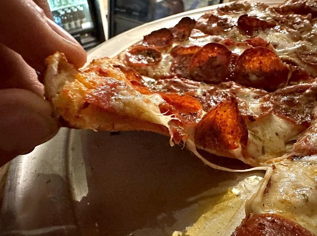 Pizza slice being lifted from the pie at Ramundo’s Pizzeria