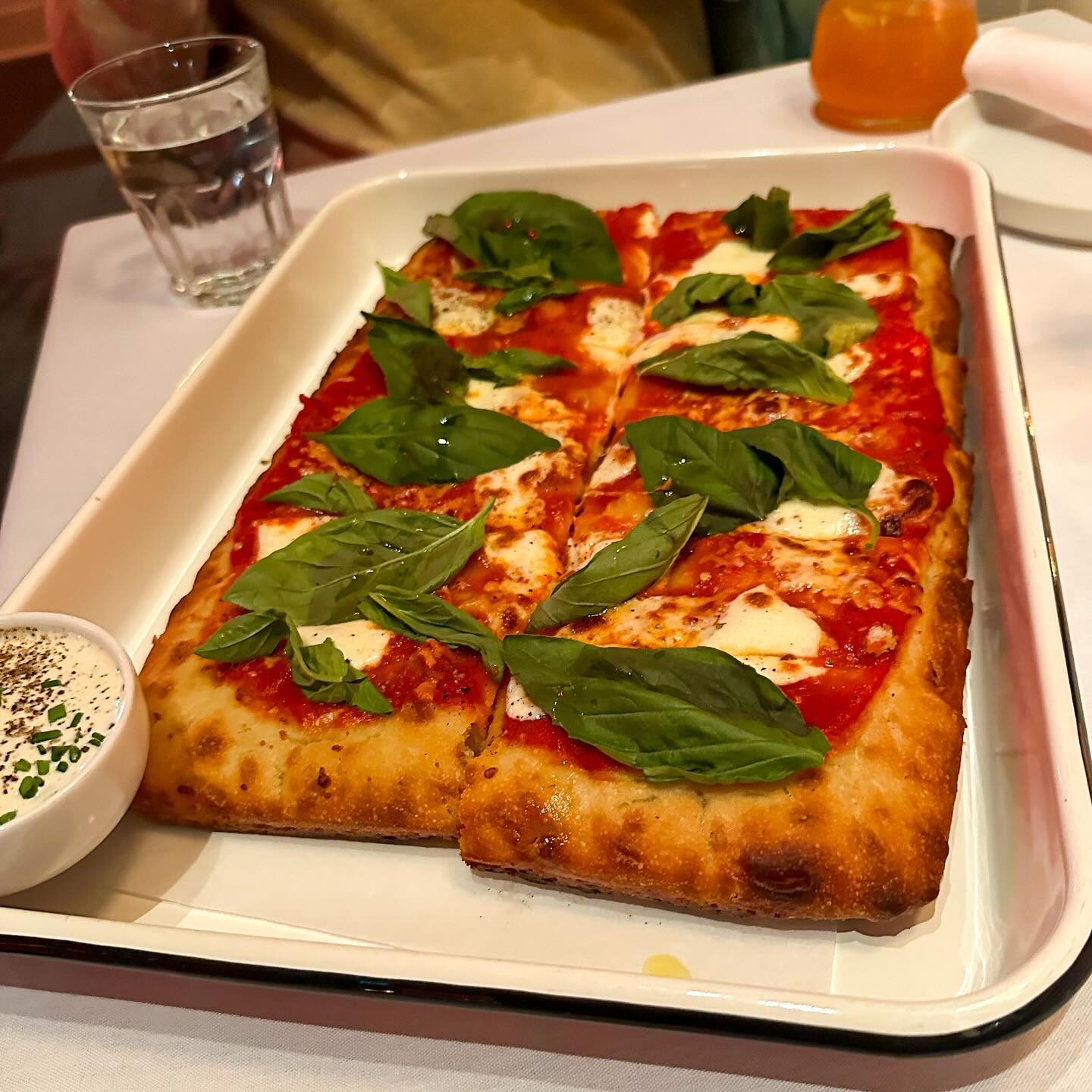 The whole Roman-style pie in its tray, both slabs topped with basil, at Razzo