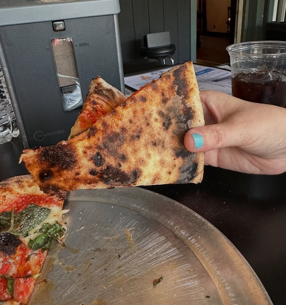 Pizza slice held up for a closer view at Rossville Pizza Company