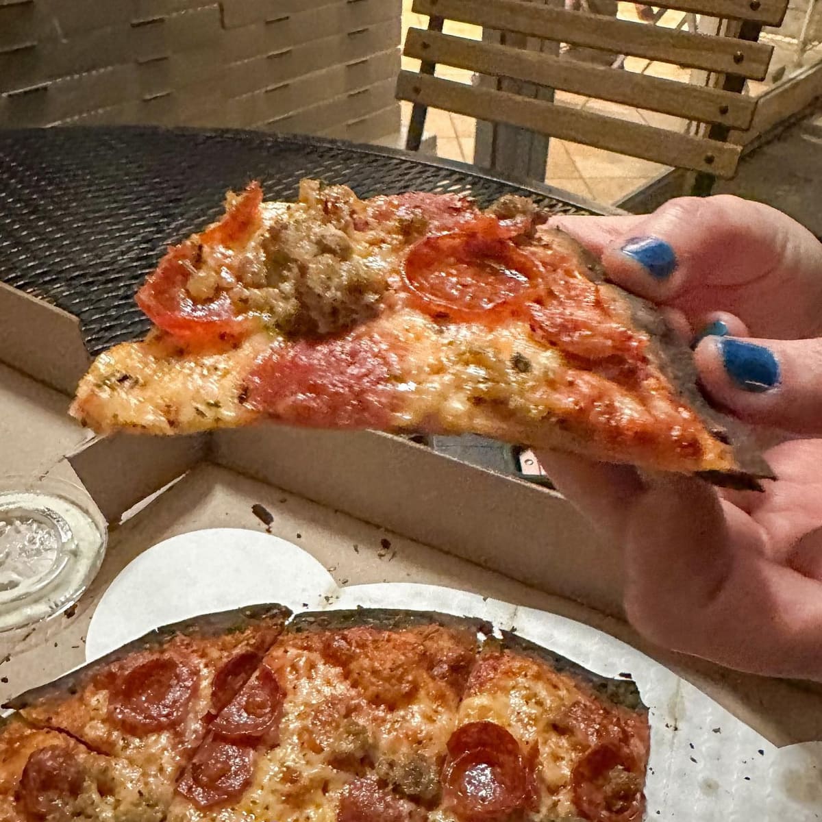 Pizza slice held up for a closer view at St Francis Apizza / Frankie’s Thin Style