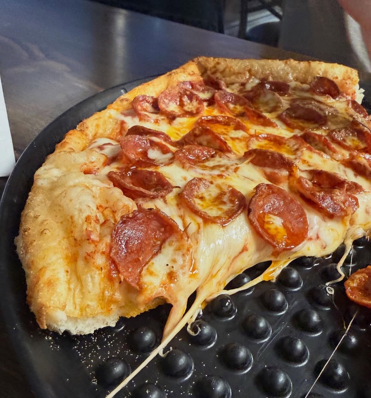 Pizza slice with melted cheese at Tony’s Pizzeria in Mason