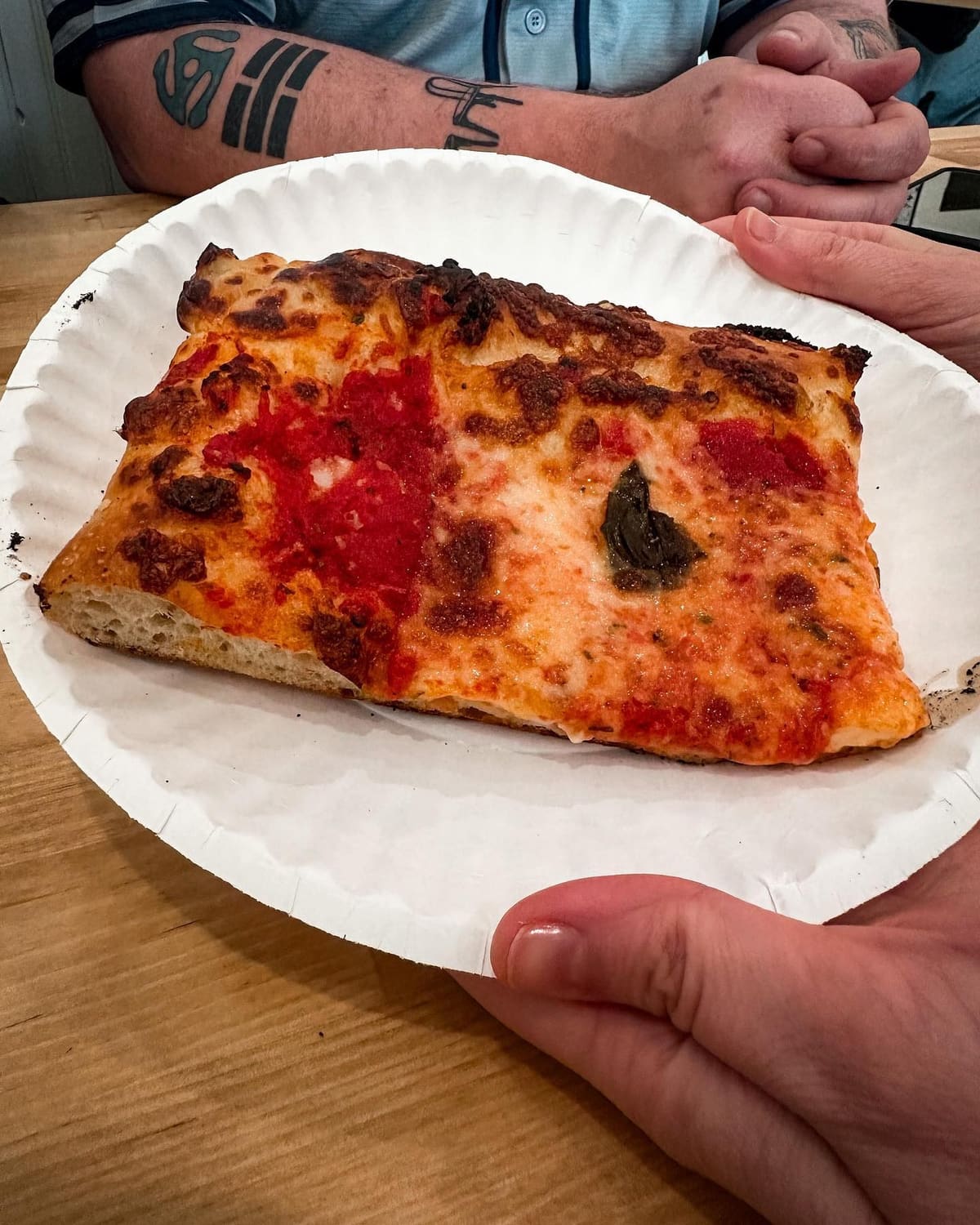 Pizza slice held up for a closer view at Trophy Pizza