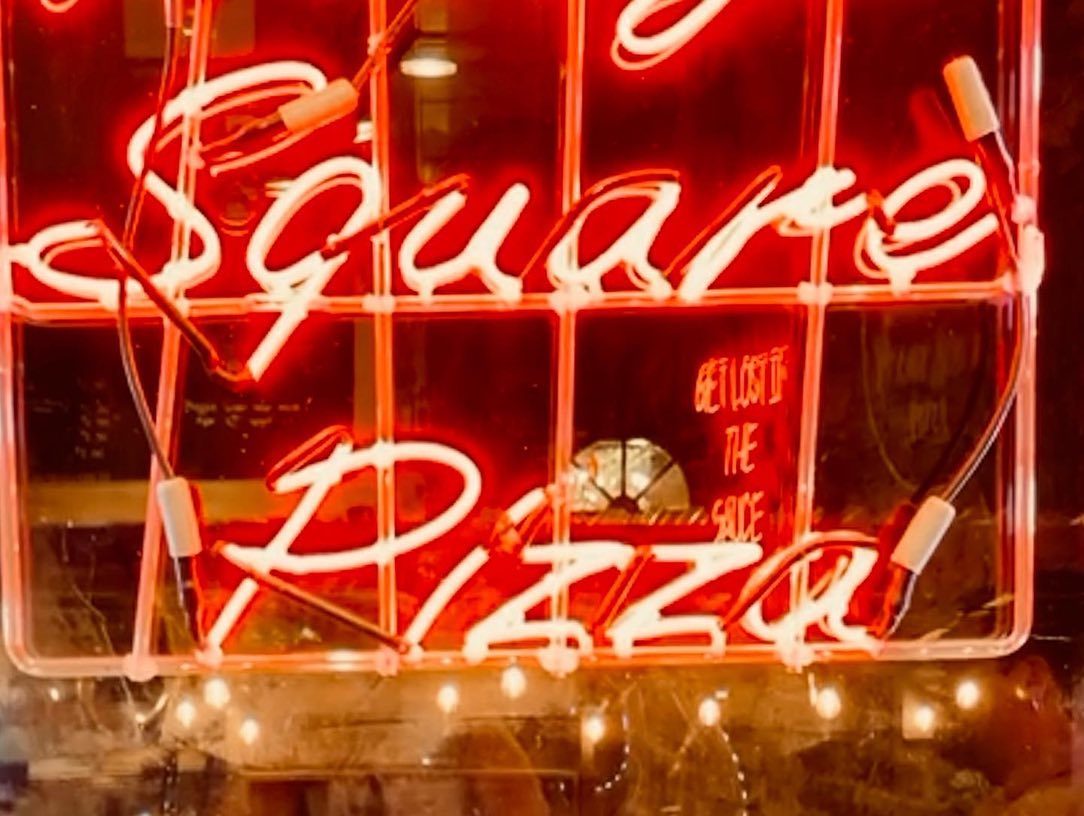 Neon sign at Village Square Pizza