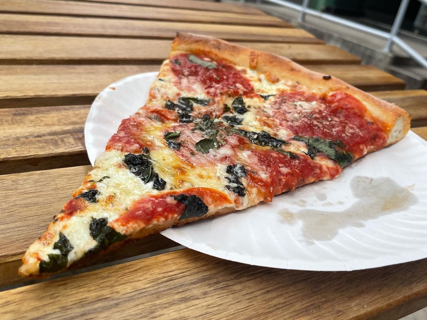 Slice with olives on a paper plate at Vito’s Slices & Ices