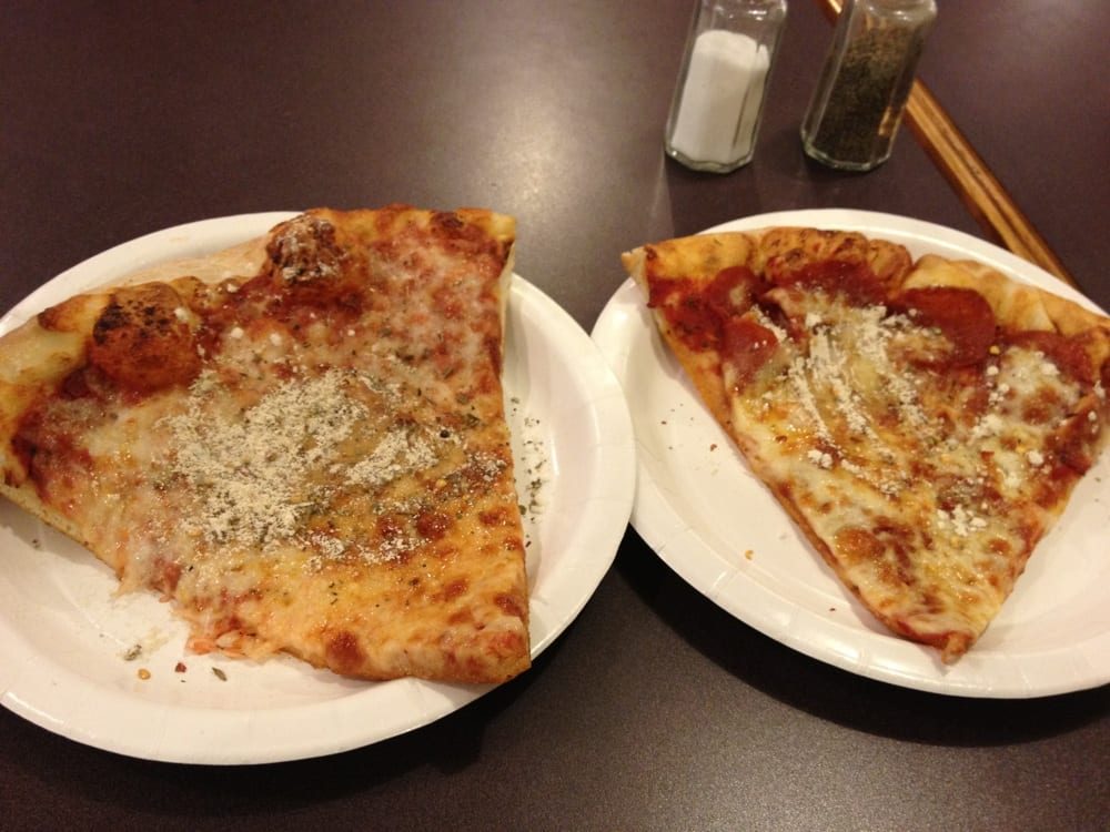 Two folded slices dusted with parmesan on paper plates, Ginelli's Pizza
