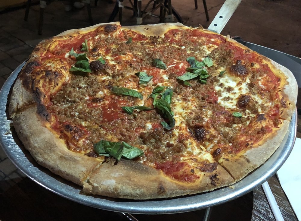 Coal-charred pie topped with sausage crumbles and basil, Cristino's Coal Oven Pizza