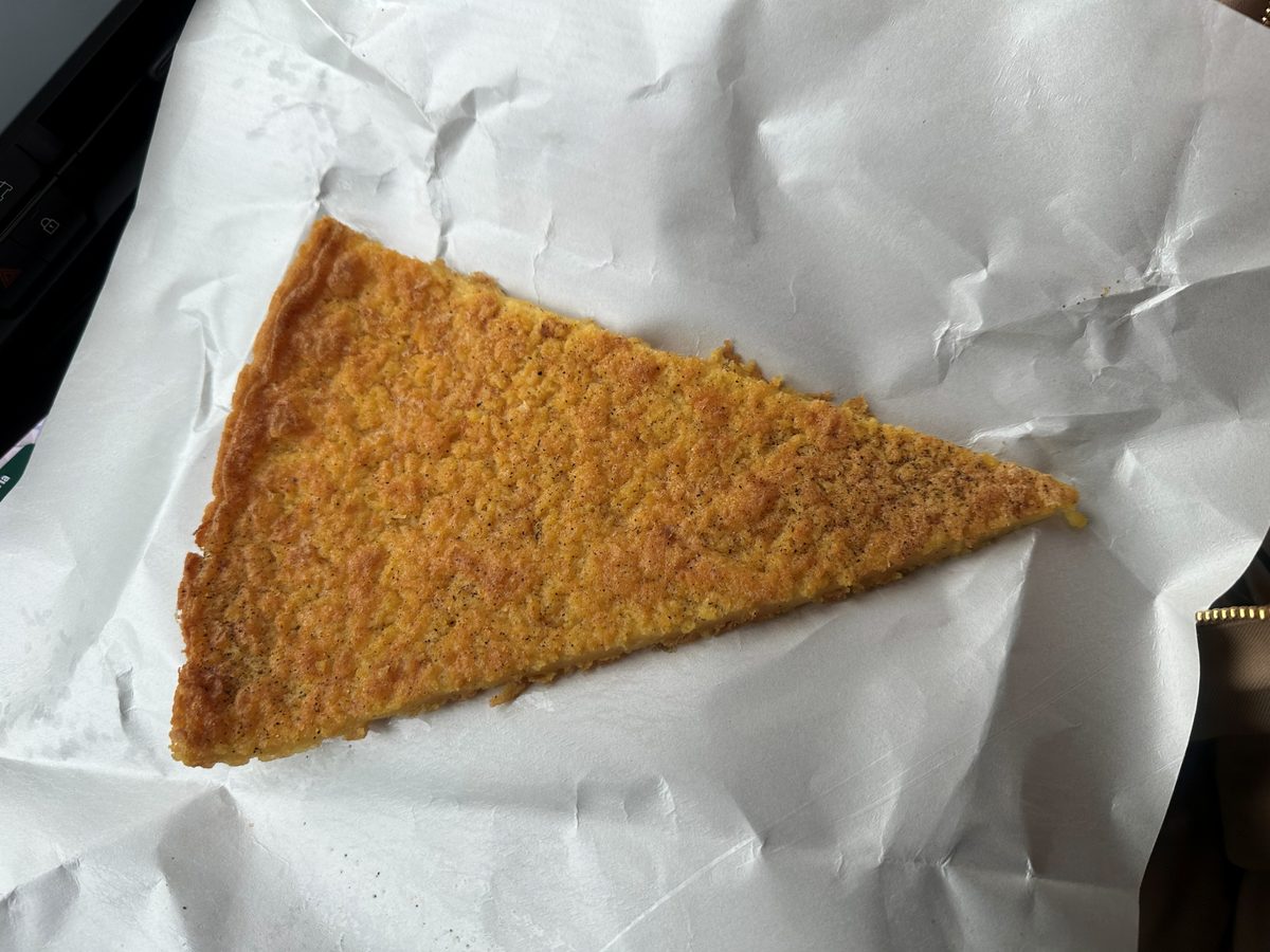 Golden wedge of chickpea flour cecina on white paper, Pane & Vino dal Piova