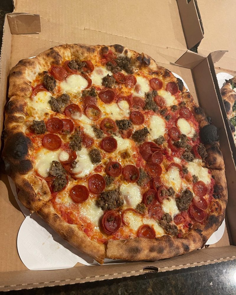 char-blistered slice piled with sausage and pepperoni cups, St Francis Apizza