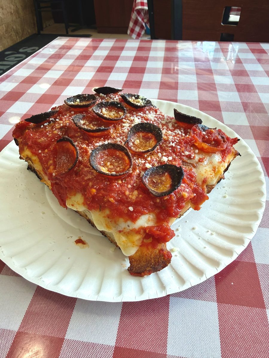 thick square slice with sauce over the cheese, blackened pepperoni cups and grated cheese, Mano's Pizza