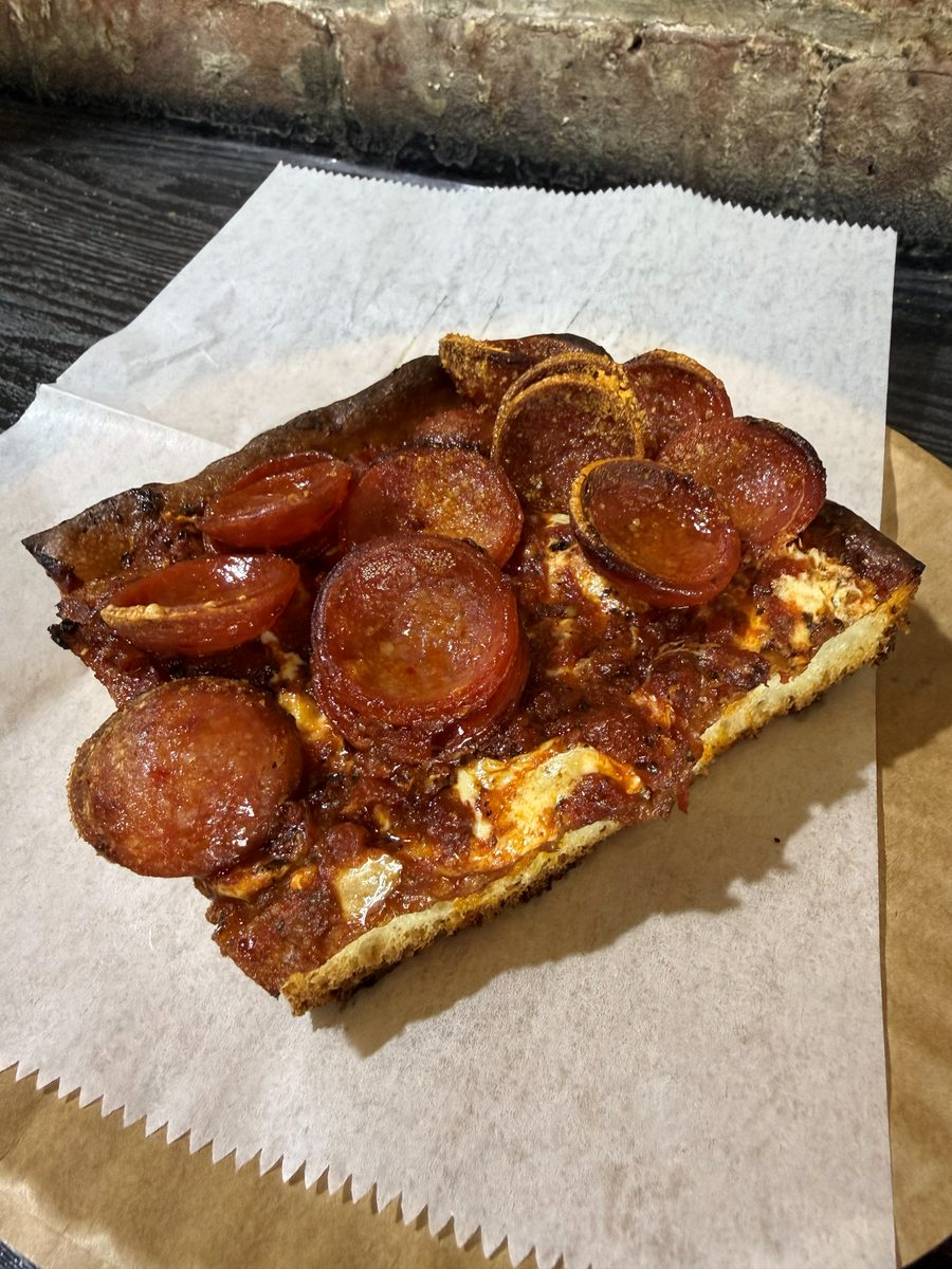 square slice under cupped, charred pepperoni on wax paper, Uncle Sam's Pizza